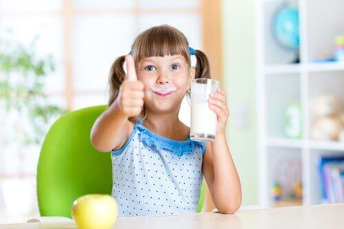 En jente som drikker et glass melk.