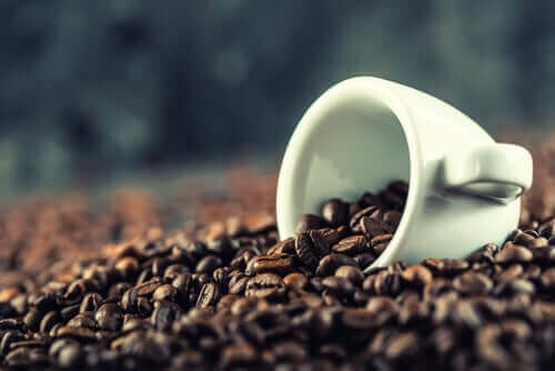 En hvit kopp i en haug av kaffebønner