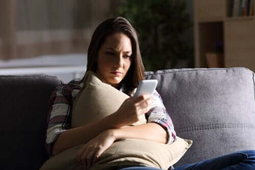 Kvinne ser på mobiltelefonen