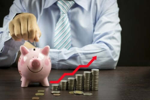 En mann som putter mynter i en sparegris