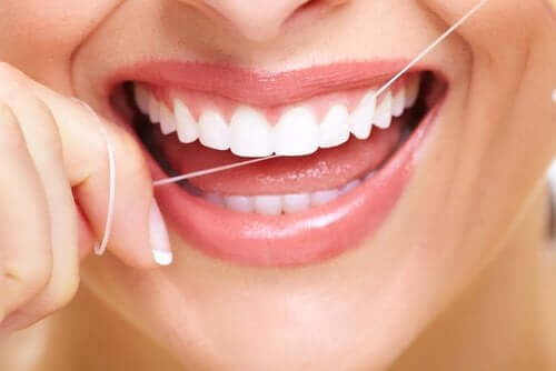 Kvinne som bruker tanntråd.
