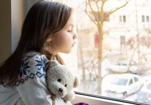 liten jente som kikker ut av vinduet