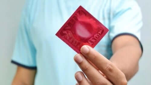 En mann som holder en kondom.