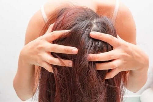 En kvinne atår bøyd med hendene i håret
