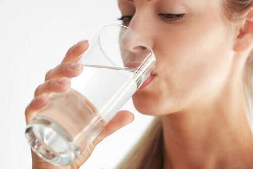 En kvinne som drikker vann.