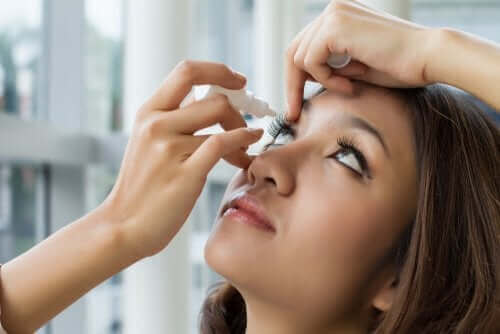 Hvordan bruke oftalmisk oksymetazolin En kvinne som tar dråper i øynene.