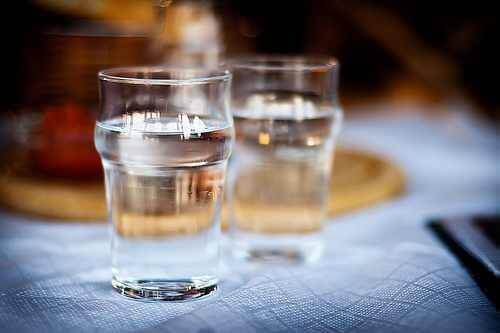 To glass vann som står på et bord.