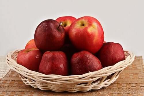 En kurv som er fylt med røde epler