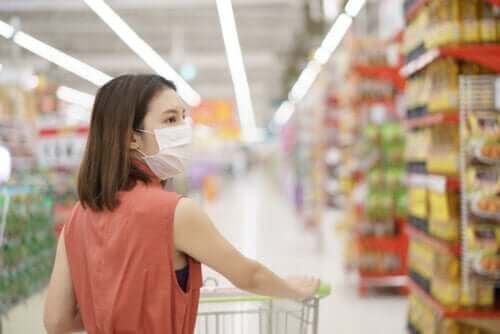 En kvinne med en maske i dagligvarebutikken