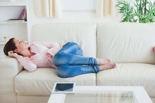 En kvinne som tar en lur på sofaen.