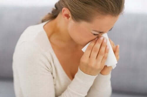 En person som nyser på grunn av allergi.