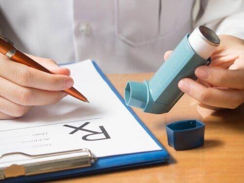 En kvinne som holder en inhalator som inneholder medikamentet ipratropiumbromid.