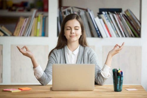 En kvinne som mediterer foran en laptop