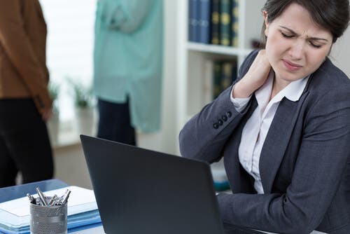 En kvinne med kontorjobb har smerter i nakken