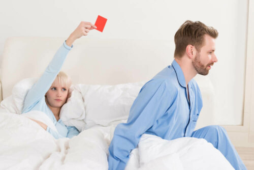 En kvinne holder et rødt kort i senga