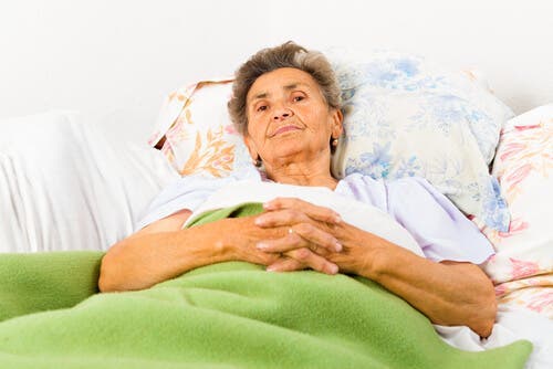 En kvinne med alzheimers ligger i sengen