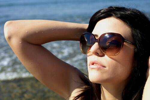  En kvinne med solbriller på stranden.