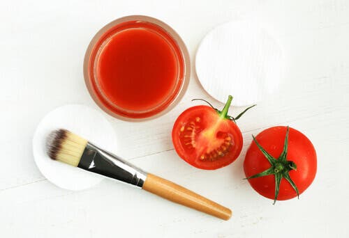 Tomater og tomatjuice på et bord sammen med en sminkebørste