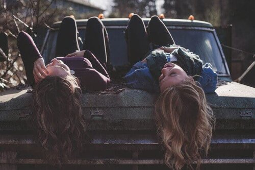 to gode venner som ligger på en gammel bil