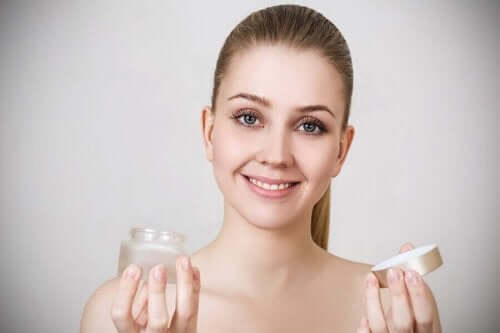 En kvinne holder en krukke med krem