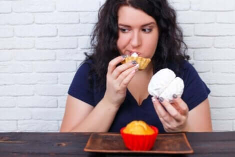 En kvinne som spiser bakverk som en av konsekvensene av overspising