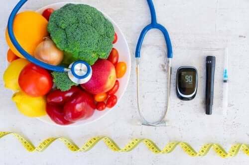 Instrumenter for diabetespleie ved siden av en bolle med frukt og grønnsaker.