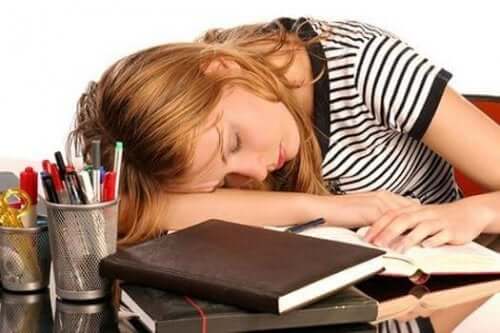 Kvinne med høyt ferritin som sover på skrivebordet.