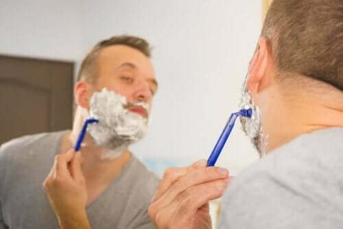 En mann som barberer seg i speilet