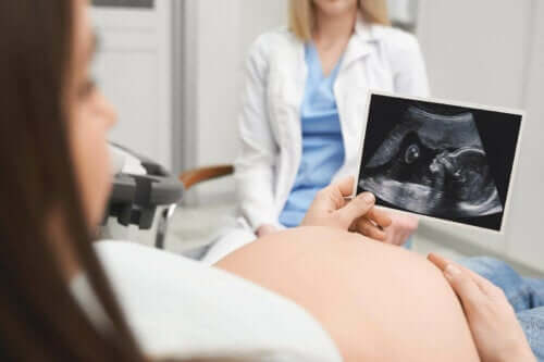 En kvinne med en ultralyd av babyen sin