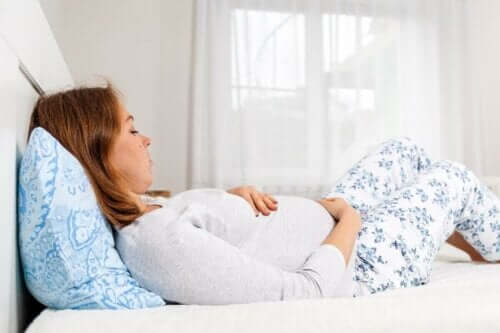En gravid kvinne som ligger i en seng