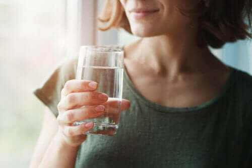 En kvinne som holder et glass vann