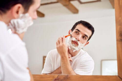 En mann som barberer seg i speilet