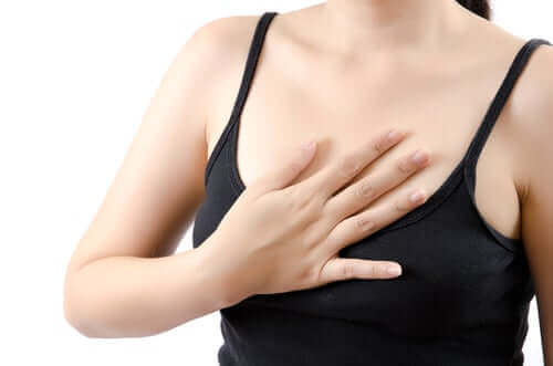 En kvinne som berører brystet