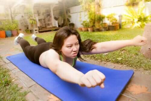 En kvinne trener mot skoliose i hagen