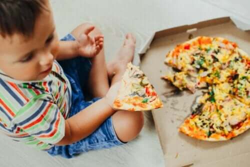 Et barn som spiser pizza.