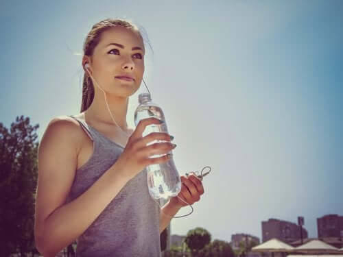 kvinne som drikker vann fra vannflaske