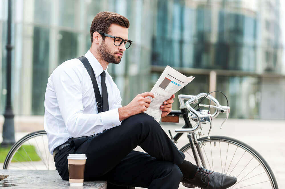 mann med briller som leser en rapport