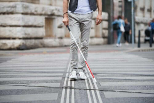 En blind person som går med stokk.