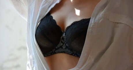 En kvinne med åpen skjorte og BH