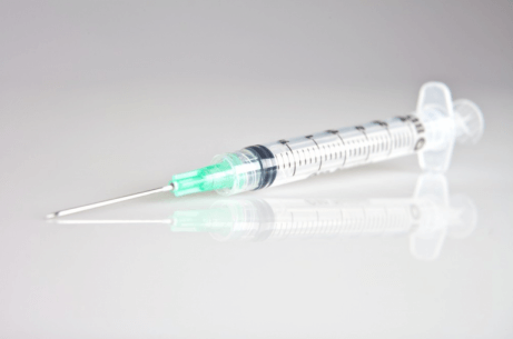 En sprøyte som ligger på en overflate.