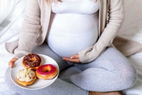 Gravid kvinne som spiser smultringer.