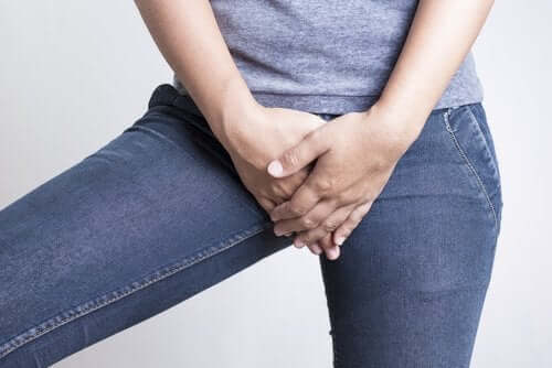 en kvinne som holder seg for skrittet