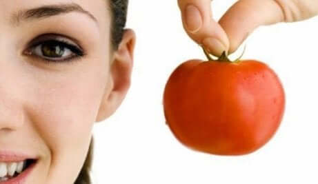 en kvinne som holder en tomat