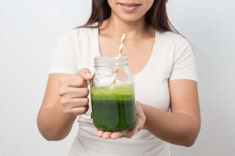 Kvinne holder et glass agurkjuice