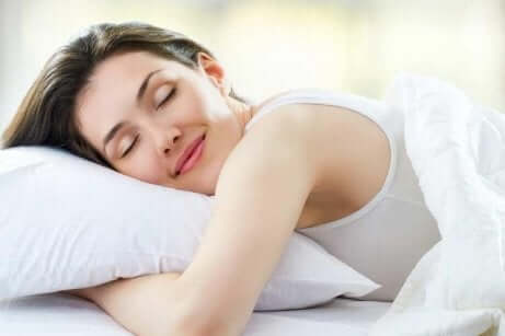 Hvordan få en god natts søvn: kvinne som sover fredelig på en pute