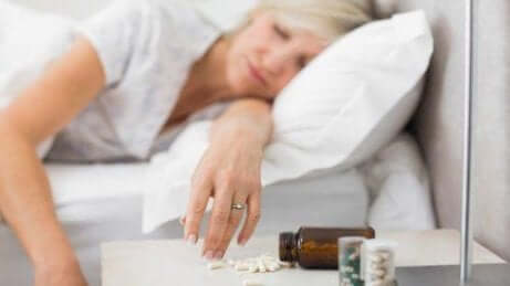 kvinne som sover ved siden av sovepiller