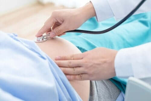 En lege som undersøker en gravid kvinne.