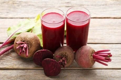 Rødbetejuice i to glass med ferske rødbeter ved siden av