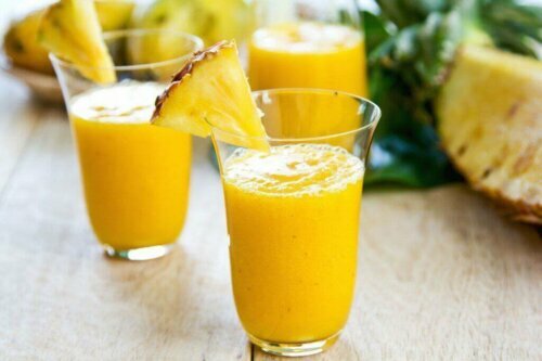 To glass med smoothie av ananas og mango