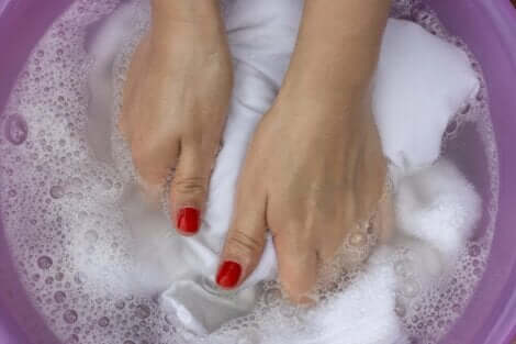 En kvinne som håndvasker hvite klær.